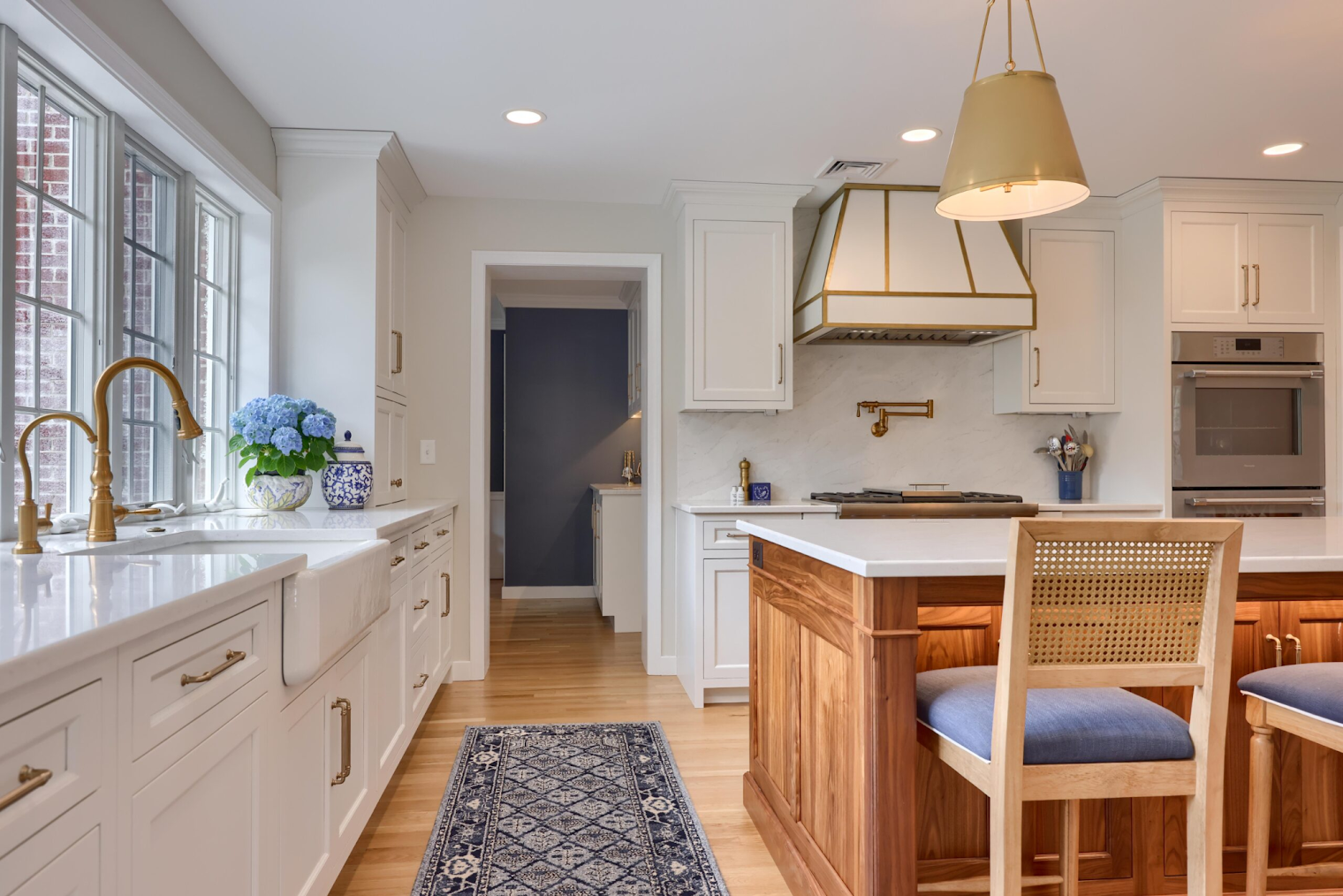 renovated kitchen with dark wood floors and white cabinetry.